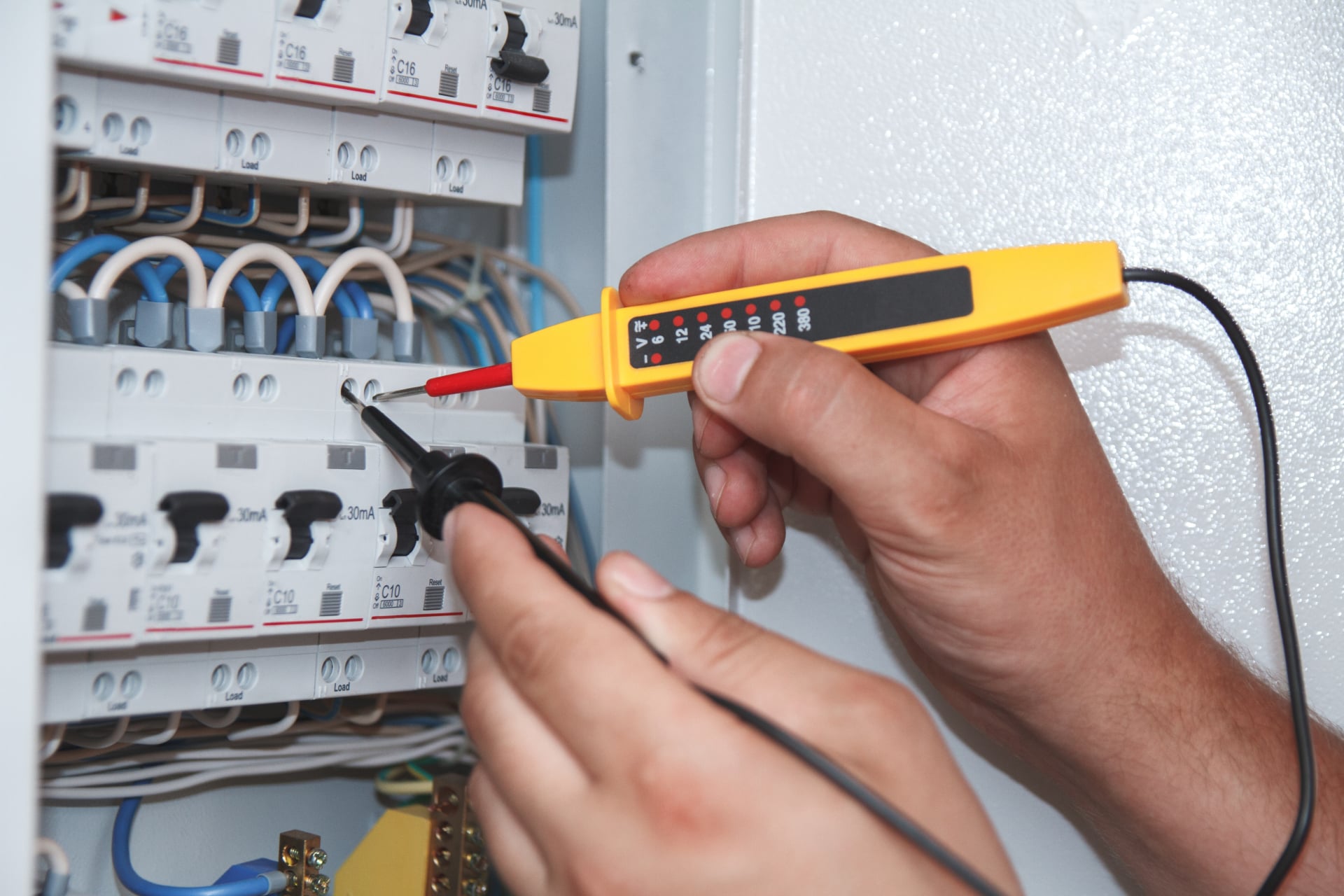 electrician-with-multimeter-probe-at-an-electrical-2024-10-17-11-37-43-utc